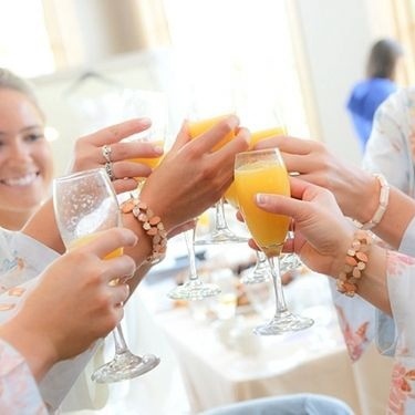 Bride and bridesmaids share a mimosa toast before the wedding reception at Hazeltine National Golf Club