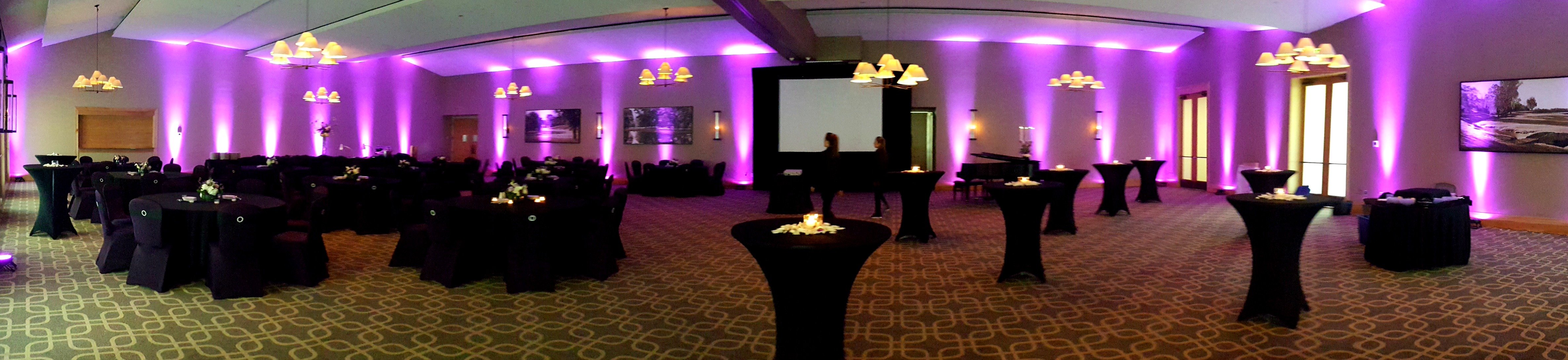 Dramatic purple uplighting set the mood in the ballroom at Hazeltine National Golf Club for a fundraising gala