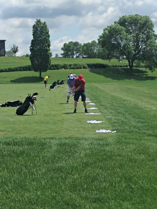 Golfers warming up on Hazeltine National Golf Club's practice range before a private golf tournament