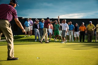 Golfers participate in a putting contest during a private golf tournament at Hazeltine National Golf Club