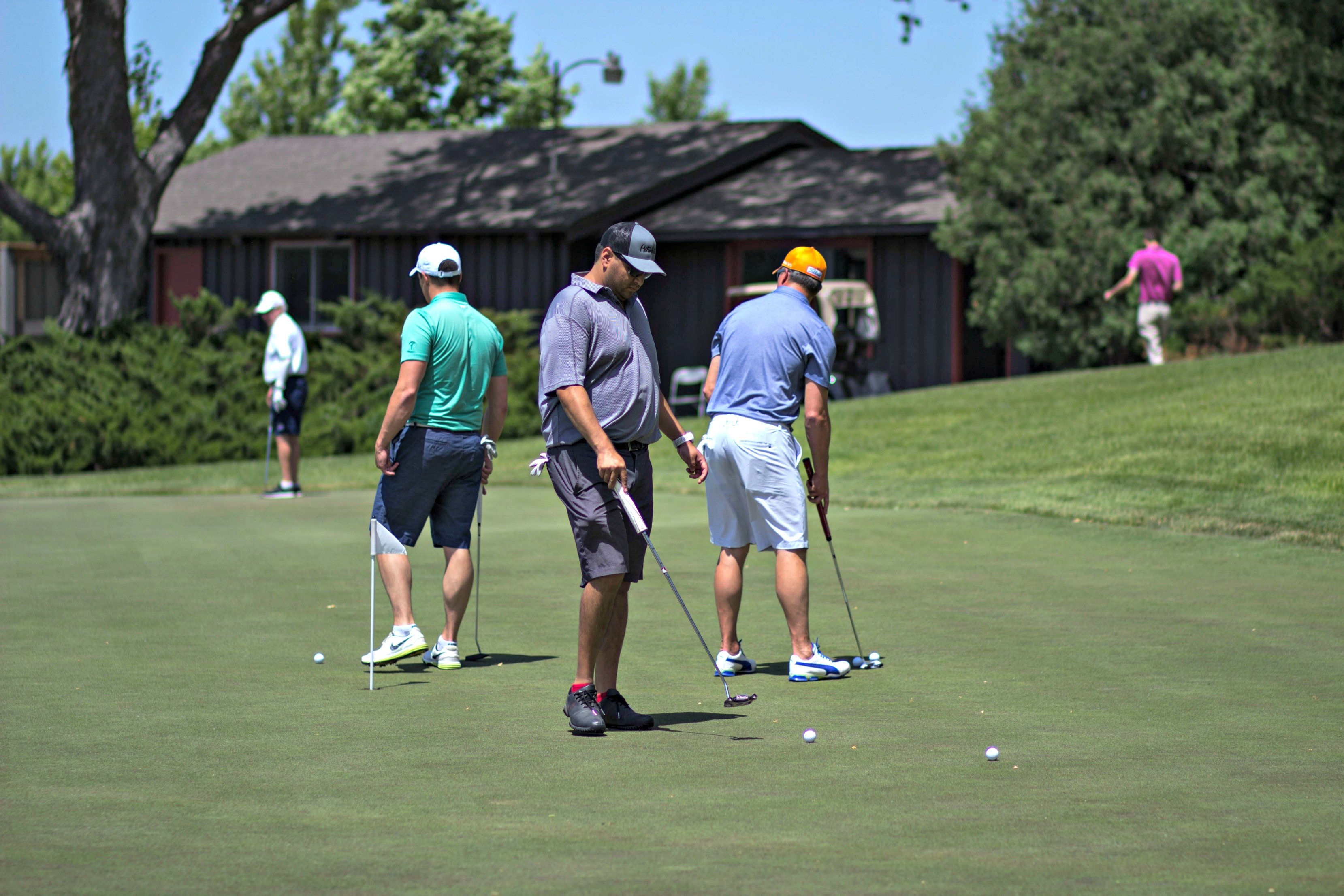 Golfers practice putting during a golf networking event at Hazeltine National Golf Club