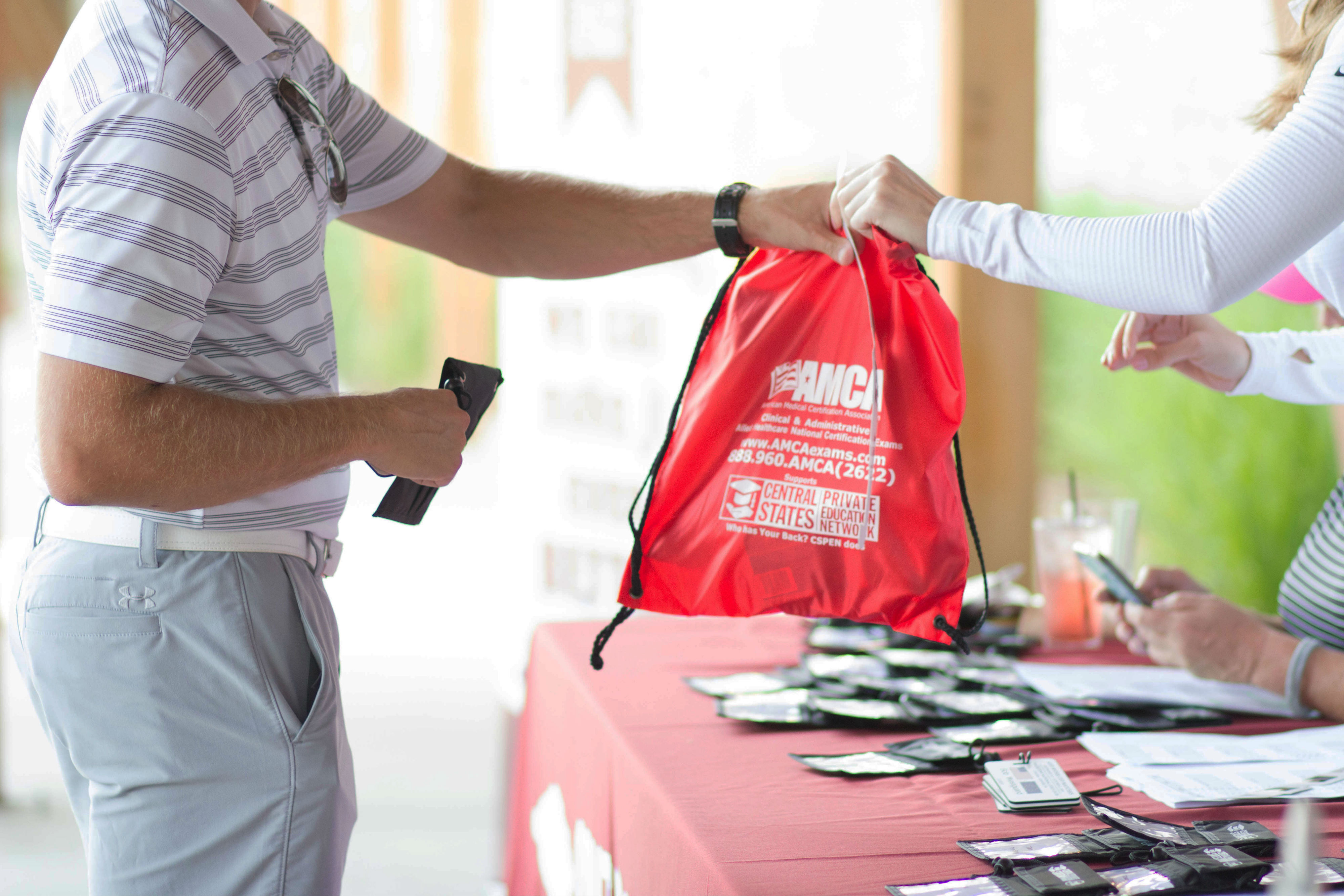Golfers are greeted at registration at a private golf tournament at Hazeltine National Golf Club