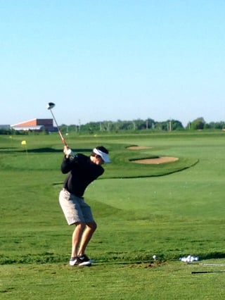Golfer hitting balls on the practice range at Hazeltine National Golf Club before a private golf touranment